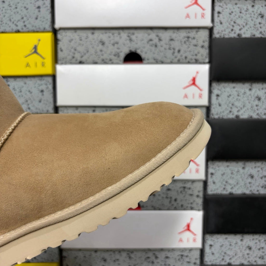 UGG Mini Bailey Bow Ankle Boot – Suede Boot with Cream Shearling Lining, Satin Bow Detail & Sand Sugar Sole in Sand